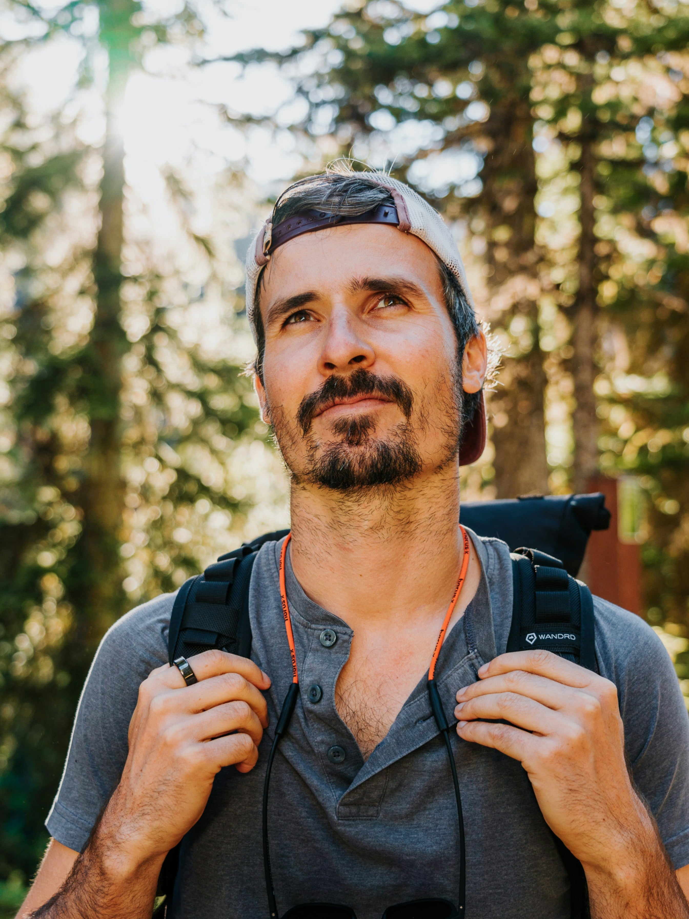 Foundoria Man with a backpack in a forest setting wearing tungra tungsten black wedding band