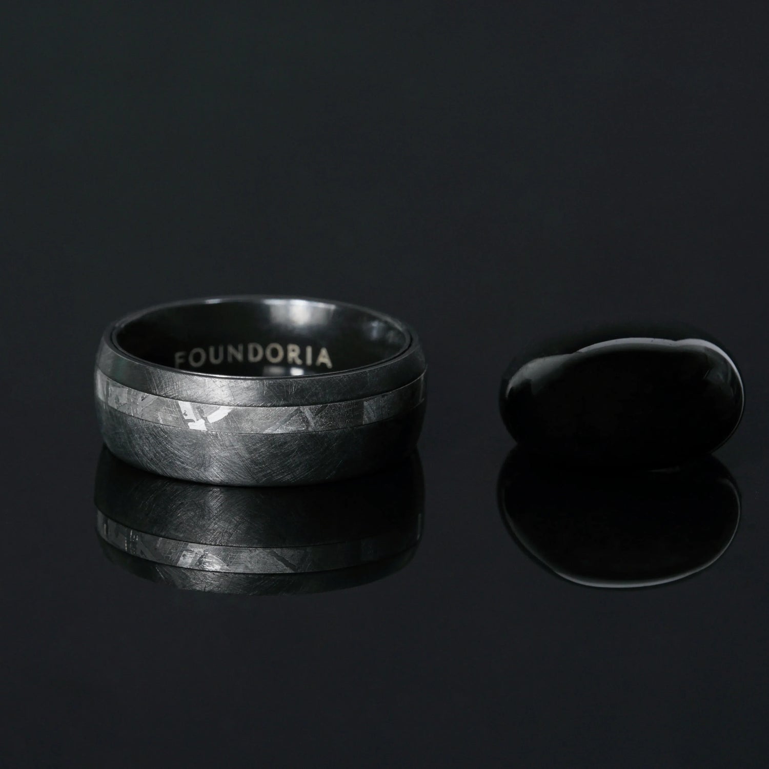 Nyx black zirconium ring beside a black tungsten band