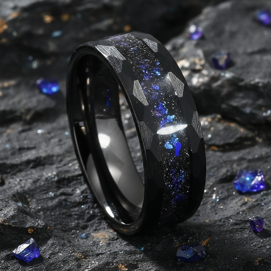 Black ring with blue and silver inlay on a dark stone surface